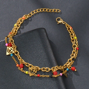 Detail of gold-plated double-layer bracelet featuring multi-colored beads and diamond pendant