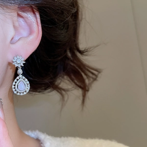 Vue macro de boucles d'oreilles fleur en argent avec pendentif goutte en zircon rose