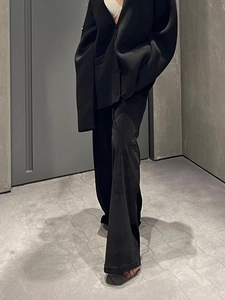 Détail d'un cardigan noir oversize à col en V associé à un pantalon large élégant