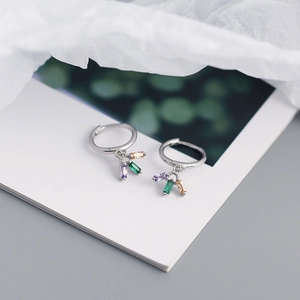 Macro shot of S925 silver hoop earrings with green, purple and champagne zircon charms