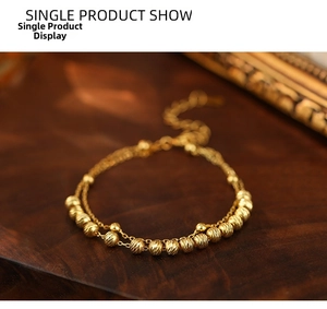 Macro shot of gold double-layer chain bracelet featuring faceted beads and vintage style