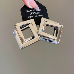 Macro detail of geometric silver rhombus earrings made of 925 sterling silver material