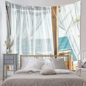 Detail of bohemian wall tapestry featuring a realistic ocean view through a white window frame