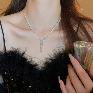 Close-up of elegant silver Y-shaped tassel necklace with sparkling zircon crystals