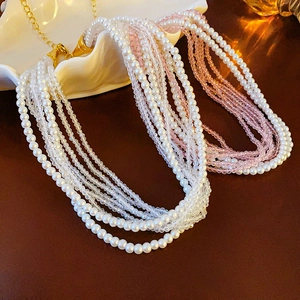 Close-up of layered bohemian pearl and crystal necklace on shell-shaped plate