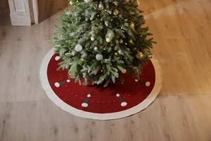 Détail de la jupe de sapin de Noël tricotée rouge avec bordure blanche et motifs