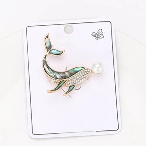 Détail de la broche baleine avec nacre d'abalone, strass brillants et incrustation de perle