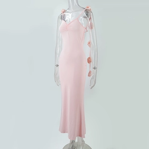 Détail de la robe longue rose clair avec fleurs 3D élégantes sur les bretelles