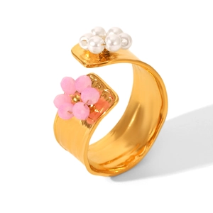 Close-up of gold open ring featuring pink crystal flower and white pearl blossom details