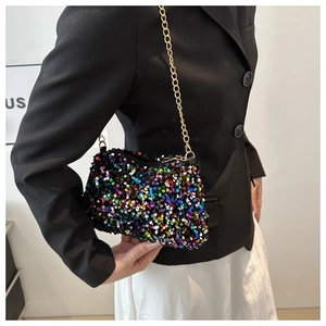 Close-up of a sequins crossbody bag with gold chain strap shown on a model outfit