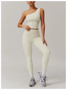 Détail d'un ensemble de yoga crème avec haut à une épaule et legging taille haute à poche