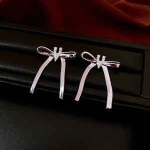 Elegant silver bowknot tassel earrings with zircons on a black leather jewelry box