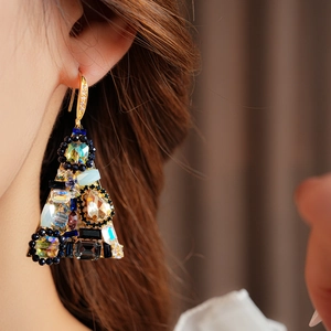 Detailed close-up of golden triangle earrings with colorful zircon and gemstone inlay