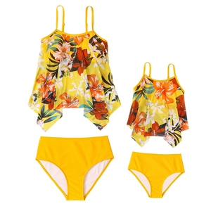 Matching mother and child two-piece swimsuits with tropical floral print and ruffles