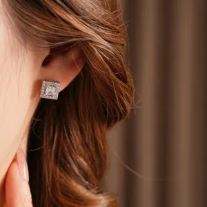 Exquisite square zircon pavé stud earrings in silver finish worn on model earlobe