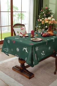 Detail of green Christmas tablecloth with reindeer and snowflake prints on wood table
