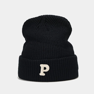 Detailed close-up of a black ribbed knit beanie with a white embroidered P letter logo