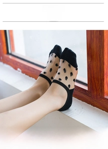 Close-up of black polka dot mesh low-cut socks with reinforced toe and heel