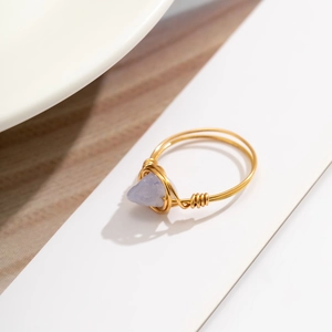 Detailed close-up of handmade gold wire-wrapped ring with a blue natural stone