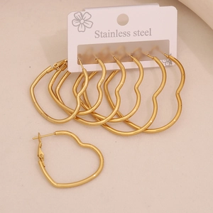 Three pairs of gold heart-shaped stainless steel hoop earrings on a display card