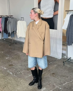 Detail view of camel oversized double-breasted blazer with shoulder pads and side slits