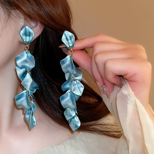 Elegant long blue petal tassel earrings with gold chain worn by a model for a stylish look