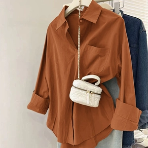 Détail d'une chemise oversize caramel avec un mini sac à chaîne matelassé blanc
