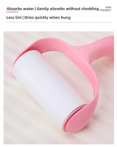 Close-up of pink lint roller with adhesive paper on a soft coral fleece towel surface
