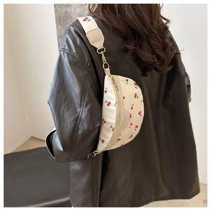 Detail of cream cherry print crossbody bag with embroidery strap on female model