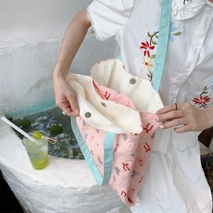 Detail showing the three-compartment interior and magnetic buckles of this pink canvas tote