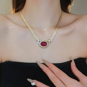 Detailed view of vintage gold snake chain necklace with oval red gemstone and pavé diamonds