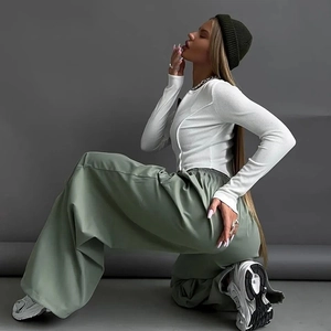 Dettaglio dei pantaloni cargo verde oliva a vita alta con taglio ampio e stile streetwear