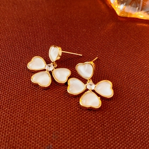 Vue détaillée de boucles d'oreilles fleurs dorées avec pétales en résine et centre en zircon