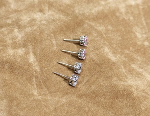 Detailed macro view of S925 silver 4-prong stud earrings with pink and white cubic zirconia