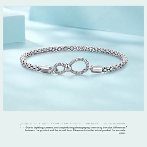 Detail of 925 sterling silver infinity clasp bracelet with mesh chain and heart accent
