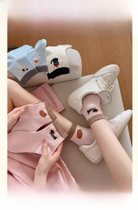 Detail showing cartoon animal embroidery and contrast rib cuffs on colorful cotton socks