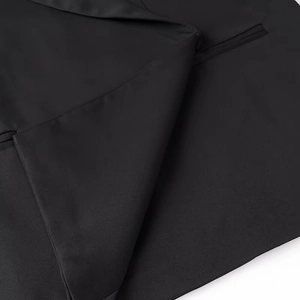 Detail shot of black blazer fabric texture featuring lapel design and pocket construction