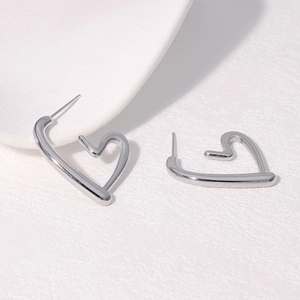Macro shot of silver hollow heart-shaped stud earrings in polished stainless steel