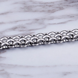 Macro detail of high-polish silver stainless steel links on cold marble background