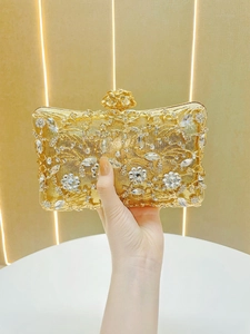 Detailed close-up of golden evening clutch bag with intricate crystal flower pattern