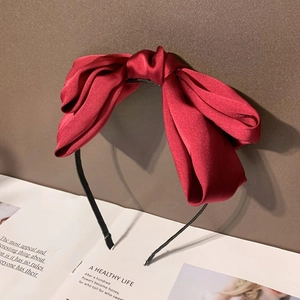 Serre-tête élégant avec grand nœud en soie rouge et bandeau noir fin en vue de face