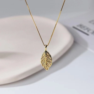 Elegant gold leaf pendant necklace with shimmering crystals for a luxury fashion style