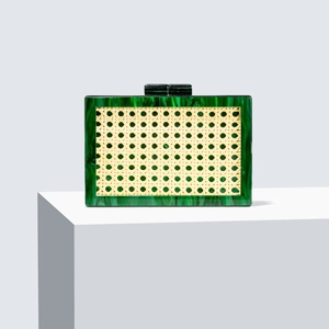 Green marble acrylic clutch bag with beige rattan panel on a white podium