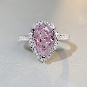 Macro shot of a S925 silver pear-cut pink gemstone ring with diamond halo detail