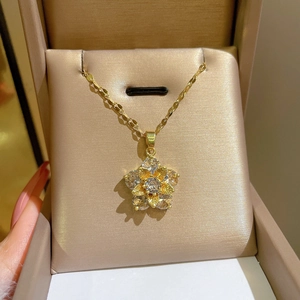 Macro detail of gold flower pendant necklace with leaf texture and sparkling zircons