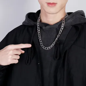 Close-up of silver flat curb chain necklace worn by a male model on a grey background