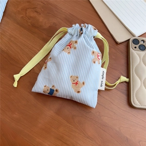 Detail of blue striped cotton drawstring bag with cute bear print and brand label