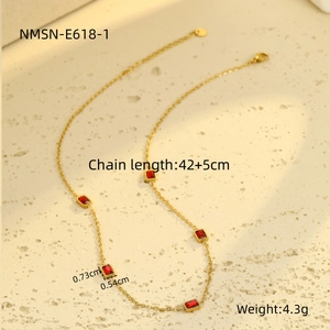 Detail shot of gold necklace featuring five red rectangular zircons and size specs