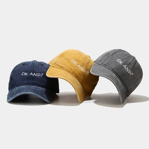 Three washed cotton baseball caps with OK AND embroidery in navy, yellow, and grey colors