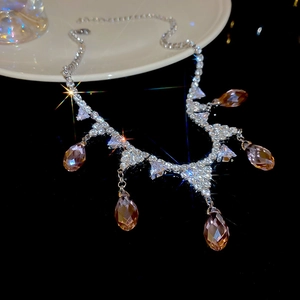 Macro detail of silver necklace with five amber zircon waterdrop pendants and crystals